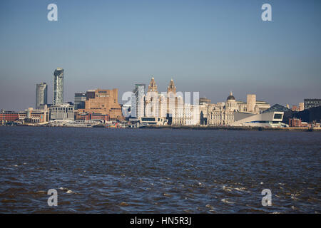 From Birkenhead side of the River Mersey looking out over Liverpool city centre on a blue sky day at landmark waterfront skyline in Merseyside, Englan