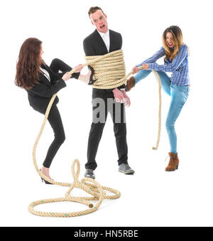 Two angry woman tying a business man with rope, isolated on a white background Stock Photo