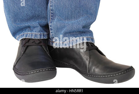 Black leather shoes, blue denim indigo jeans, casual men's sneakers closeup, man's feet foot, legs isolated studio shot Stock Photo