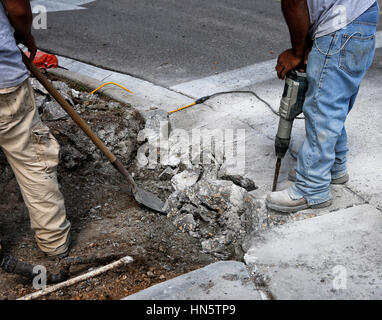                         Save  Download Preview     Road construction: Street workers are drilling concrete in bright sunny day Stock Photo