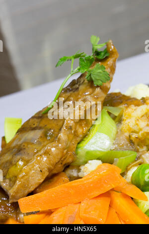 A close up view of a dish of Braised Sirloin Steak served with Creamed potatoes and vegetables. Stock Photo