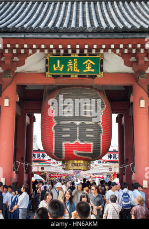 TOKYO - MAY 24 : People walk under the lantern that hangs inside the Kaminarimon or Thunder Gate in the district of Asakusa in Japan's capital city on Stock Photo