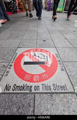 Naha, Japan - April 2, 2012: A no smoking warning sign built into the pavement of Kokusaidori, a busy tourist street in the city of Naha in Okinawa pr Stock Photo