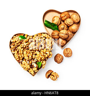 Walnut kernels in heart shaped box, whole walnuts and nutshells as healthy eating and alternative medicine concept, objects isolated on white backgrou Stock Photo