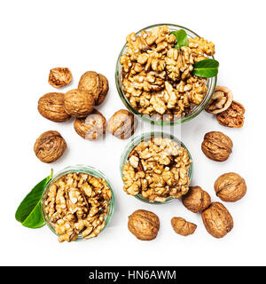 Walnut kernels in glass bowl, whole walnuts and nutshells as healthy eating and dieting concept, group of objects isolated on white background Stock Photo