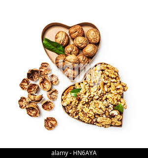 Walnut kernels in heart shaped box, whole walnuts and nutshells as healthy eating and alternative medicine concept, objects isolated Stock Photo