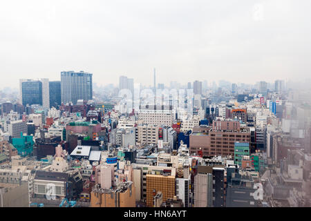 Tokyo, Japan - March 2, 2012: Elevated view of the Tokyo skyline taken through the window of a Shinjuku hotel room on an overcast day. White vignette  Stock Photo