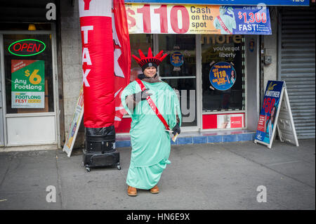 A worker dressed as the Statue of Liberty promotes Liberty Tax Preparation services in the the Hub, in the Melrose section of the New York borough of the Bronx on Sunday, February 5, 2017. The Hub Central Business District gets it's name from the convergence of four roads, East 149th Street, Willis, Melrose and Third Avenues and is the oldest major shopping district in the borough.  (© Richard B. Levine) Stock Photo
