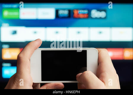 close up of smartphone as remote of smart tv Stock Photo