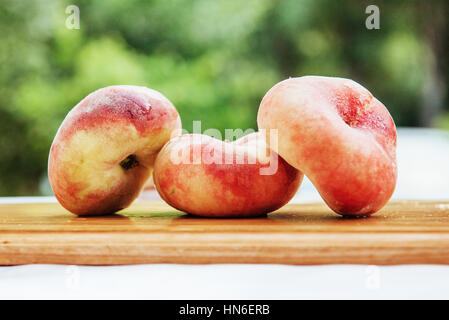 flat peaches on wood table Stock Photo