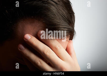 man covering his head with hand suffering from headache Stock Photo