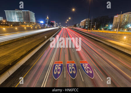 Atlanta, Georgia, USA - February 15, 2014:  Interstate highway 85 pavement signs, downtown skyline and traffic at night. Stock Photo