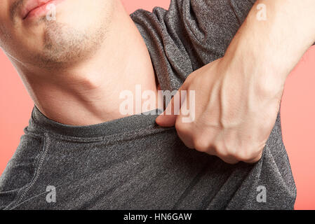 close up of hand grabbing man shirt on pink background Stock Photo