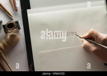 Calligraphy studio, hand writes text with ink, pen and nib, Roman Capitalis writing on Ingres paper Stock Photo