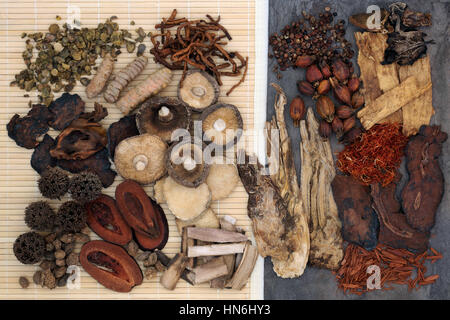 Traditional chinese herb selection used in herbal medicine on bamboo and marble. Stock Photo