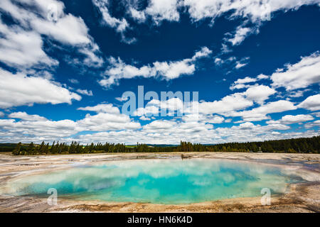 Turquoise Pool, a hot spring, with reflection in the Midway Geyser Basin of Yellowstone National Park, Wyoming Stock Photo