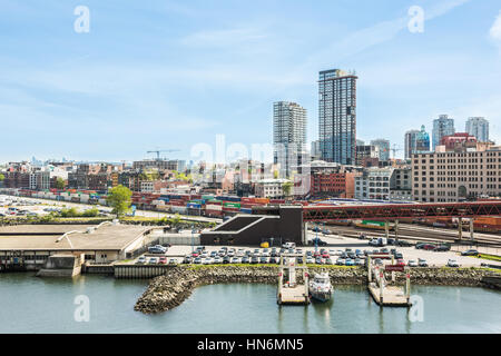 Vancouver, Canada - April 19, 2016: City downtown skyline or cityscape with industrial port with cars, cargo, containers and trains on Harbour Stock Photo