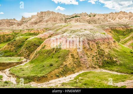 Dried up stream in Badlands National Park with green grass and canyons Stock Photo