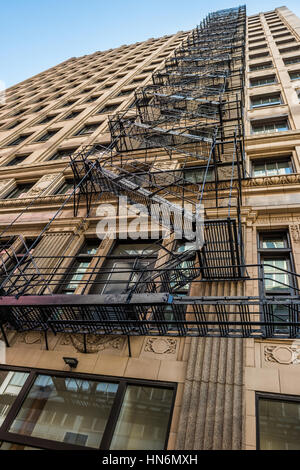 Old and rusty fire escape ladders and staircase in downtown Chicago on skyscraper Stock Photo
