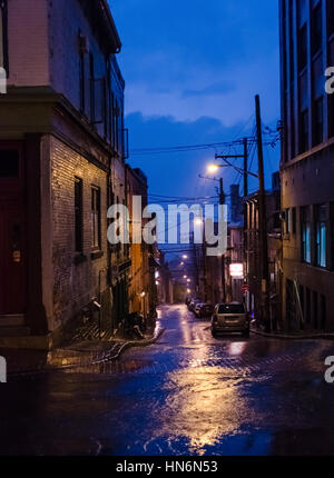 Quebec City, Canada - July 27, 2014: Dark alley way at night in downtown during blue hour with lamps Stock Photo
