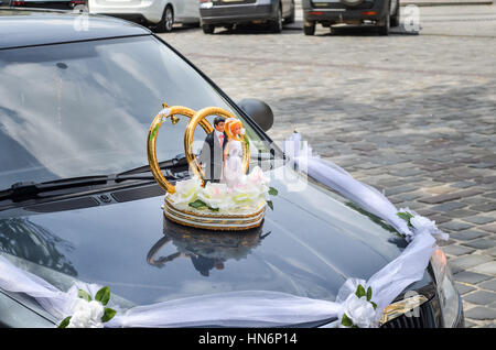 Wedding decoration on car with bride and groom Stock Photo