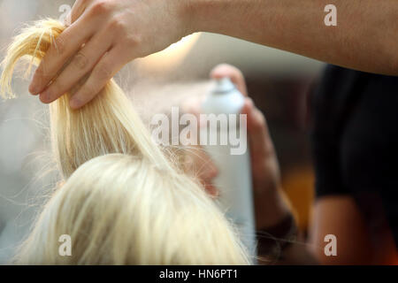 Hairdresser arranging hairdo using hairspray Stock Photo