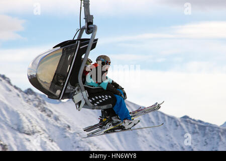 FLACHAU, AUSTRIA - DEC 27: Skiiers on a ski lift to a piste in Flachau, Austria on Dec 27, 2012. These pistes are part of the Ski Armada network, the  Stock Photo