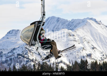 FLACHAU, AUSTRIA - DEC 27: Skiiers on a ski lift to a piste in Flachau, Austria on Dec 27, 2012. These pistes are part of the Ski Armada network, the  Stock Photo