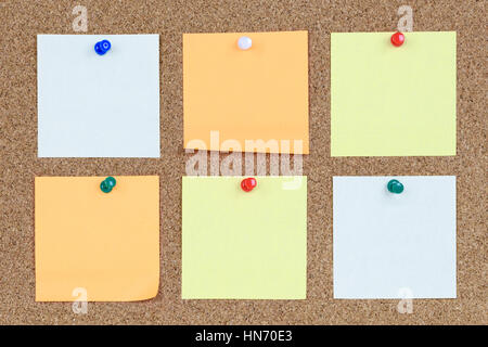 Six various and blank sticky notes on an office cork bulletin board. Stock Photo