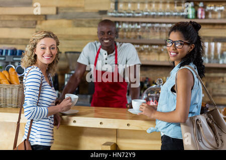 Waiter serving coffee to female customer in cafÃƒÂ© Stock Photo