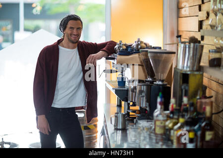 Portrait of smiling owner standing near espresso machine in cafÃƒÂ© Stock Photo