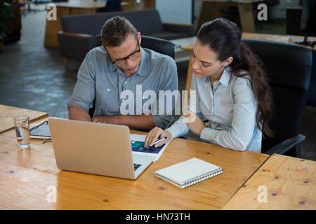 Business executives discussing over document in office Stock Photo