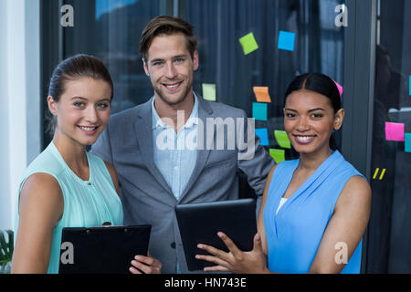 Portrait of graphic designers discussing over digital tablet in office Stock Photo