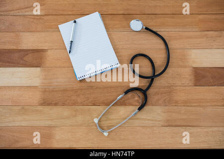 Stethoscope with pen on notebook desk Stock Photo