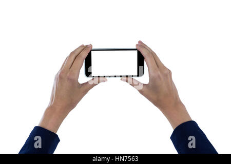 Hand of businesswoman holding mobile phone against white background Stock Photo