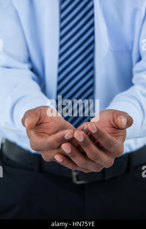 Mid section of mans hands cupped with sugar cubesagainst white background Stock Photo