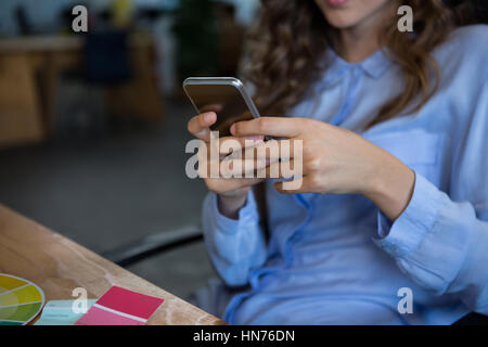 Mid section of female graphic designer using mobile phone in office Stock Photo