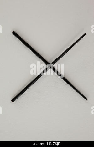 Pair of black chopsticks against white background Stock Photo