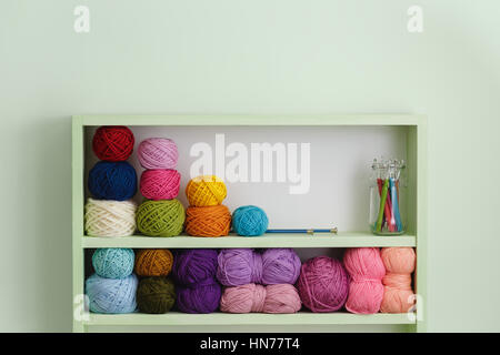 Colorful Balls Of Wool On Shelves. Variety of knitting yarns. Different Yarn balls in multiple colors. Yarn Storage. Stock Photo