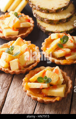Tart filled with fresh pineapple and jam closeup on the table. vertical Stock Photo