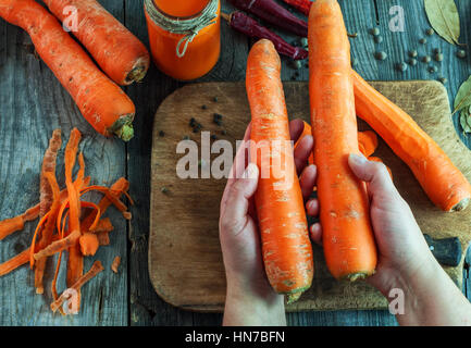 Two large ripe carrots lie in female hands, top view Stock Photo