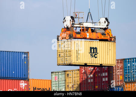 ROTTERDAM, THE NETHERLANDS - MAR 16, 2016: Container being moved by a crane operator in the Port of Rotterdam. Stock Photo