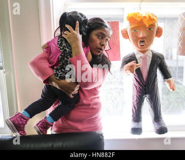 Los Angeles, California, USA. 9th Feb, 2017. Immigrant Mario Vargas' wife LOLA holds her daughter ATHENA, 1, as she reacts to a President Donald Trump paper doll in a news conference before a court appearance on Thursday. Vargas attended his first removal hearing before an immigration judge since being released from Immigration Detention in 2014. Vargas was accompanied by his daughter, Jersey, who, when she was 10, traveled to Rome three years ago and asked Pope Francis - one day before he was to meet with President Barack Obama - to intervene to prevent her father's deportation. (Credit Stock Photo