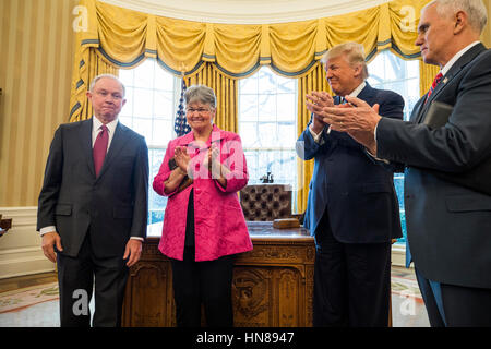 Attorney General Jeff Sessions (L) smiles while Sessions' wife, Mary Blackshear Sessions (C-L), U.S. President Donald J. Trump (C-R), and Vice President Mike Pence (R) clap after he was sworn-in as attorney general in the Oval Office of the White House in Washington, DC, USA, 09 February 2017. On 08 February, after a contentious battle on party lines, the Senate voted to confirm Sessions as attorney general. Credit: Jim LoScalzo/Pool via CNP /MediaPunch Stock Photo