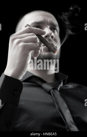 Businessman's hand with cigar on black background Stock Photo