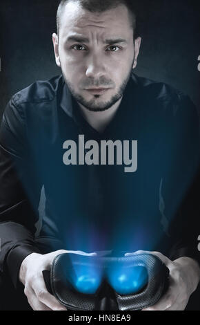 Portrait of businessman that is holding glowing Virtual Reality headset Stock Photo