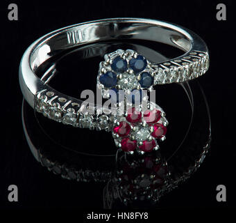 white gold ring with blue and red diamonds isolated on black Stock Photo