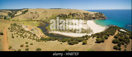 Aerial panorama of Middle River flowing to the ocean via Snelling Beach among yellow hills on Kangaroo Island, South Australia Stock Photo