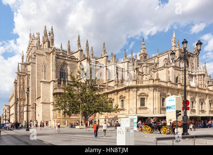 Seville, Spain - April 30, 2016: The Seville Cathedral, view from the south, horse-drawn carriage in front, people walking by. Santa Maria de la Sede  Stock Photo