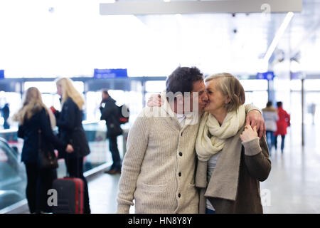 Senior couple standing in hallway of subway, kissing Stock Photo